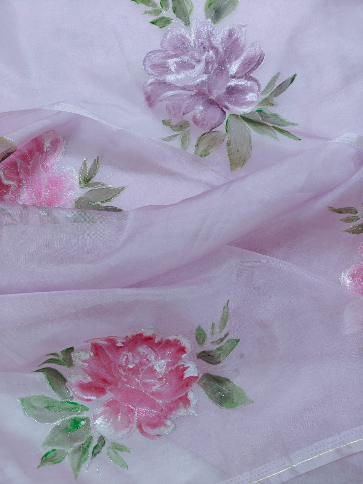 Hand-painted pink floral motifs on softly draped blush organza