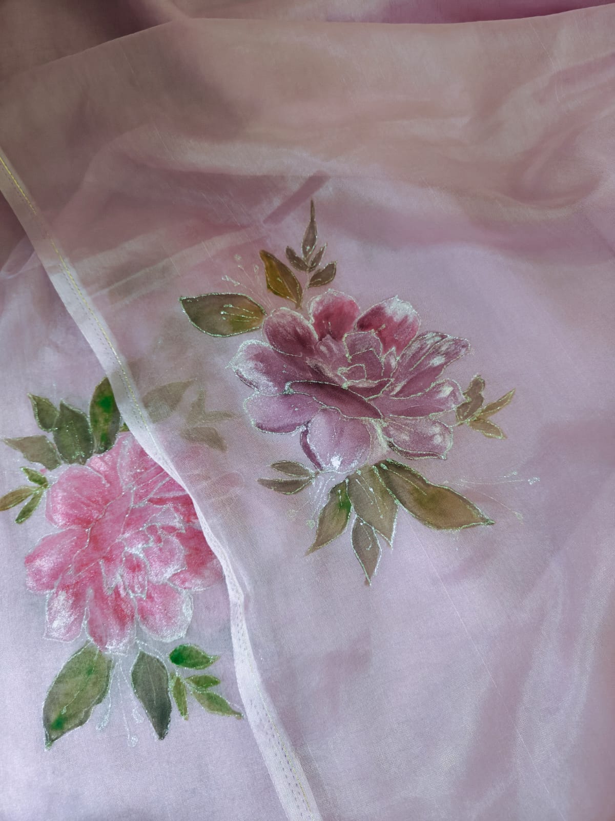 Close view of hand-painted pink roses on blush organza